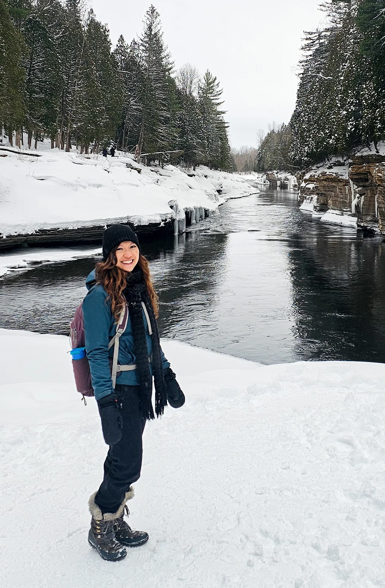 Ultimate Things To Do In Quebec City In Winter women standing close to a river with ice and snow covered banks